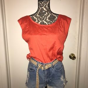 Red blouse with open back. Denim daisy dukes.